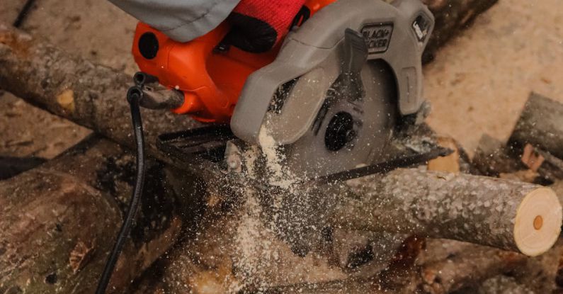 Key Cutting Machines - A person using a chainsaw to cut logs