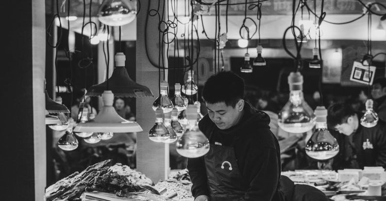 Key Cutting - A black and white photo of a woman at a market