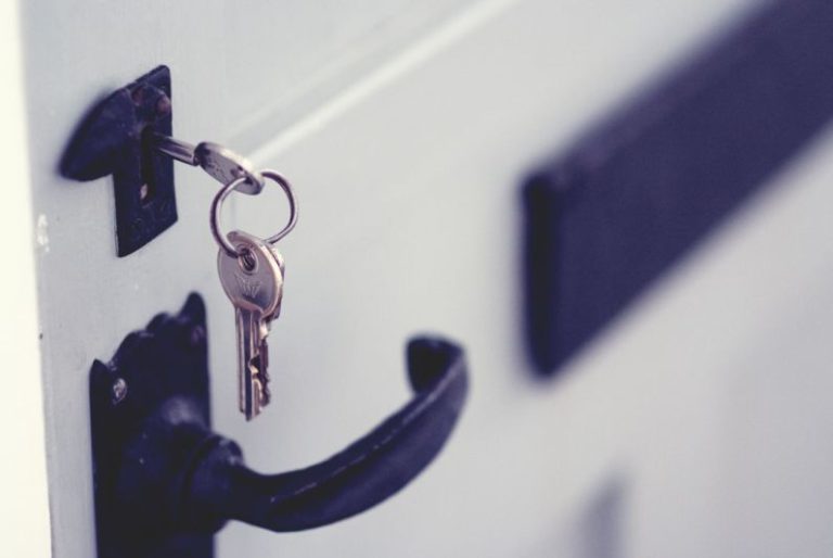 Rekey - black and silver padlock on white door