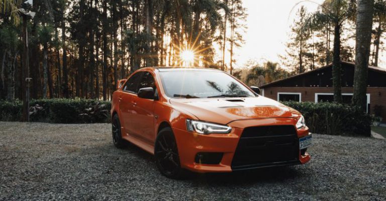 Car Lockouts - An orange car parked in front of a forest