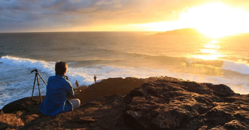 Lockout - Person Sitting on Cliff Watching Sunset