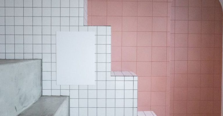 Keyless Entry - White blank paint hanging on tile white wall near arched entrance in room with minimalistic design